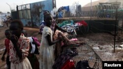 South Sudanese girls displaced by the fighting collect their laundry from a barbed wire in a camp for displaced persons in the UNMISS compound in Tongping in Juba February 19, 2014. Thousands of people have been killed and more than 800,000 have fled thei