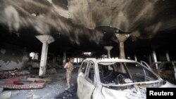 지난 16일 예멘 사나에서 한 군인이 공습으로 파손된 차량을 수색하고 있다.