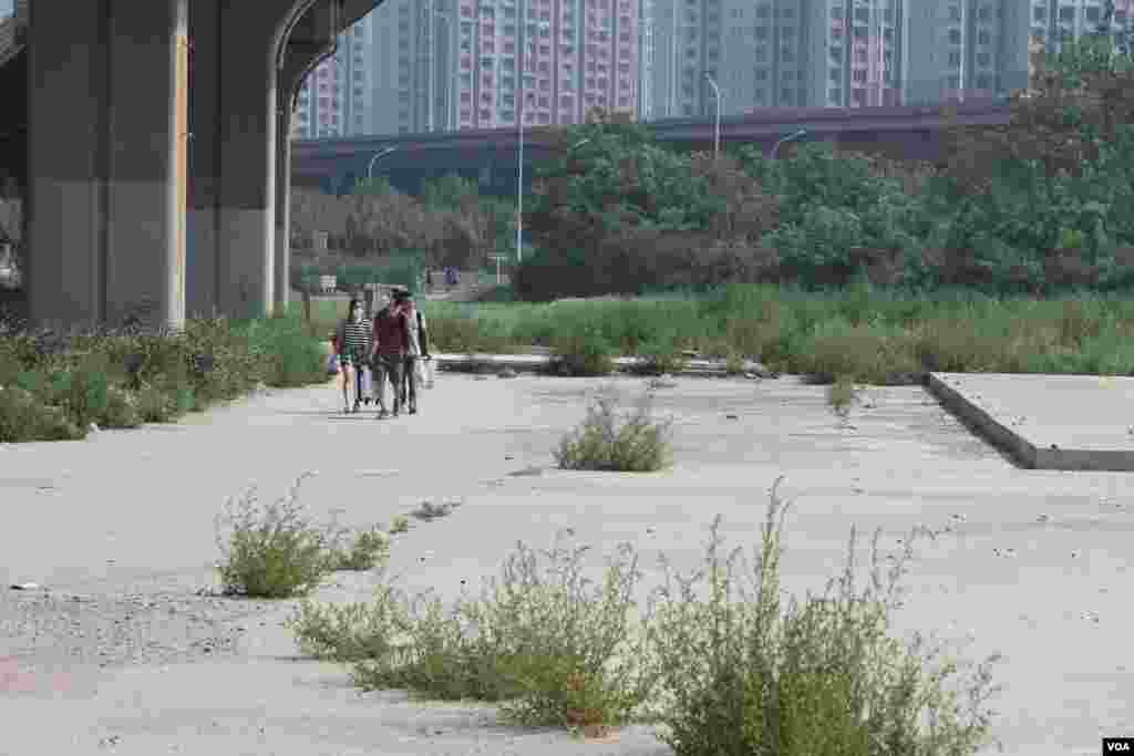 天津爆炸事故现场，核心爆炸区周围多座居民楼窗户被震碎，高速公路桥梁受损，多辆大货车被炸翻，小汽车起火或被砸，多名当地居民仍逗留在事故现场。（美国之音记者东方拍摄）