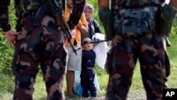 匈牙利士兵拦住一家希望从塞尔维亚进入匈牙利的移民或难民。 （2015年9月15日）