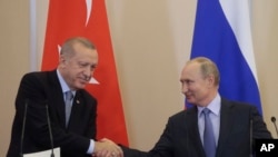 Russian President Vladimir Putin, right, and Turkish President Recep Tayyip Erdogan shake hands after their joint news conference following their talks in the Bocharov Ruchei residence in the Black Sea resort of Sochi, Russia, Oct. 22, 2019. 