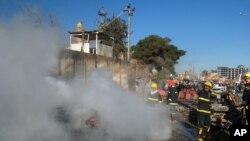 Para petugas pemadam kebakaran mencoa memadamkan api yang berkobar pasca ledakan bom di Kirkuk, 290 kilometer sebelah utara Baghdad, Irak, 3 Februari 2013. (AP Photo/Emad Matti)