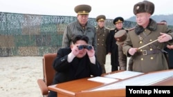 Pemimpin Korea Utara Kim Jong Un mengamati latihan militer dengan menggunakan teropong (Foto: dok).