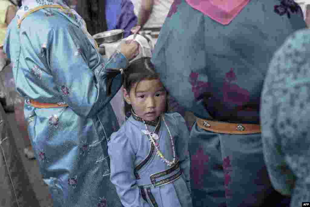 在蒙古乌兰巴托，蒙古人民革命党候选人在竞选大会上演讲时，一位小姑娘等待妈妈（2017年6月23日）