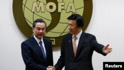 South Korean Foreign Minister Yun Byung-se gesture to his Chinese counterpart Wang Yi (L) before their meeting at the Foreign Ministry in Seoul, May 26, 2014. 