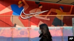 资料图：一名妇女走过北京的一家耐克产品专卖店。 （2021年3月25日）