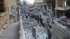 People inspect the damage at a site after it was hit by shelling carried out by rebels at Syrian government-held areas of Aleppo, Syria, in this handout picture provided by SANA, July 11, 2016.