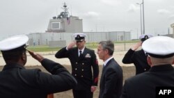 NATO Secretary-General Jens Stoltenberg (C) reviews an honor guard during an inauguration ceremony of the U.S. anti-missile station Aegis Ashore Romania (in the background) at the military base in Deveselu, Romania, May 12, 2016. 