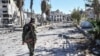 FILE - A member of the Syrian Democratic Forces (SDF) walks through a heavily damaged street leading to an Armenian church in Raqqa, Syria, Oct. 18, 2017.