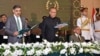In this handout photograph taken and released by the Pakistan's Press Information Department (PID) on August 14, 2023, Pakistan's President Arif Alvi (C) administers the oath to Anwaar-ul-Haq Kakar (L) as caretaker Prime Minister during an oath-taking cer