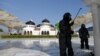 Seorang polisi mengenakan pakaian hazmat menyemprotkan disinfektan di sebuah masjid untuk mencegah penyebaran virus corona (COVID-19) di Banda Aceh, Aceh, 20 Maret 2020. (Foto: Antara via Reuters)