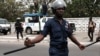 Des policiers montent la garde alors que des manifestants défilent à Accra, la capitale du Ghana, contre l'expansion de sa coopération en matière de défense avec les États-Unis, Ghana, le 28 mars 2018.