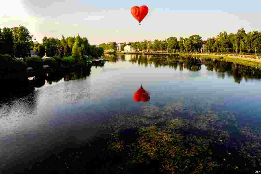 A hot air balloon flies over the Lovat River during the 24th International Balloon Meet in the town of Velikie Luki, Russia, June 11, 2019.