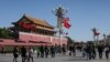 A U.S. flag is displayed beside a Chinese flag as tourists flock outside the Forbidden City in Beijing, Nov. 12, 2014. 