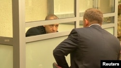 Russia -- A still image from a video footage shows Estonian police officer Eston Kohver talking to a lawyer (R) from a defendants' cage during a court hearing in Pskov, Russia, June 2, 2015.