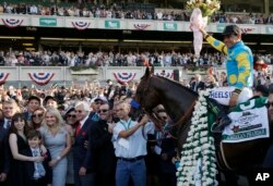 Victor Espinoza sits astride American Pharoah in the winner's circle after gliding to victory in the 147th running of the Belmont Stakes at Belmont Park in Elmont, N.Y., June 6, 2015.