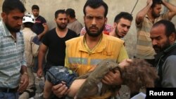 医护人员抱着一个死于阿勒颇空袭的孩子的尸体（2016年10月4日））