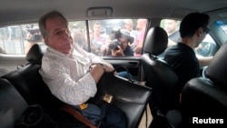 Antonio Celso Grecco, propietario de Rodrimar, una compañía que prestaba servicios en el puerto de Santos, en Brasil, es escoltado por un guardia federal en la sede de la Policía en Sao Paulo, Brasil. 