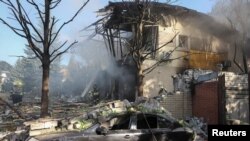 Пожарные работают на месте частного дома, разрушенного во время российского ракетного удара, в Харькове, Украина, 24 июля 2024 года