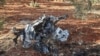 This picture taken on Sept. 20, 2021, shows a vehicle destroyed by what is believed to be a drone strike, on the northeastern outskirts of Syria's rebel-held northwestern city of Idlib. 