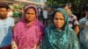 Sabila Dafadar, left, waits at a traffic intersection, hoping to get a job as a construction laborer. (Anjana Pasricha/VOA)