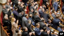우크라이나 의회가 28일 새 시위 및 집회법의 폐지를 결의한 후, 의원들이 박수를 치고 있다.