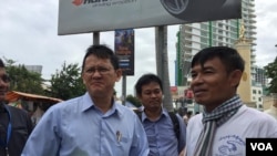 លោក នី ចរិយា (ឆ្វេង) អតីត​មន្រ្តី​ការពារ​សិទ្ធិ​មនុស្ស​អាដហុក និង​ជា​អ្នក​ ដែល​រង​ការជាប់ចោទ​ពី​បទ​សមគំនិត​សូកប៉ាន់​សាក្សី ឈរ​ជជែក​ជាមួយ​អតីត​អ្នកសារព័ត៌មាន​វិទ្យុ​អាស៊ី​សេរី ក្រោយ​ចេញ​ពី​សាល​សវនាការ​សាលា​ដំបូង​រាជធានី​ភ្នំពេញ នៅ​ថ្ងៃទី២៧ ខែសីហា ឆ្នាំ២០១៨។