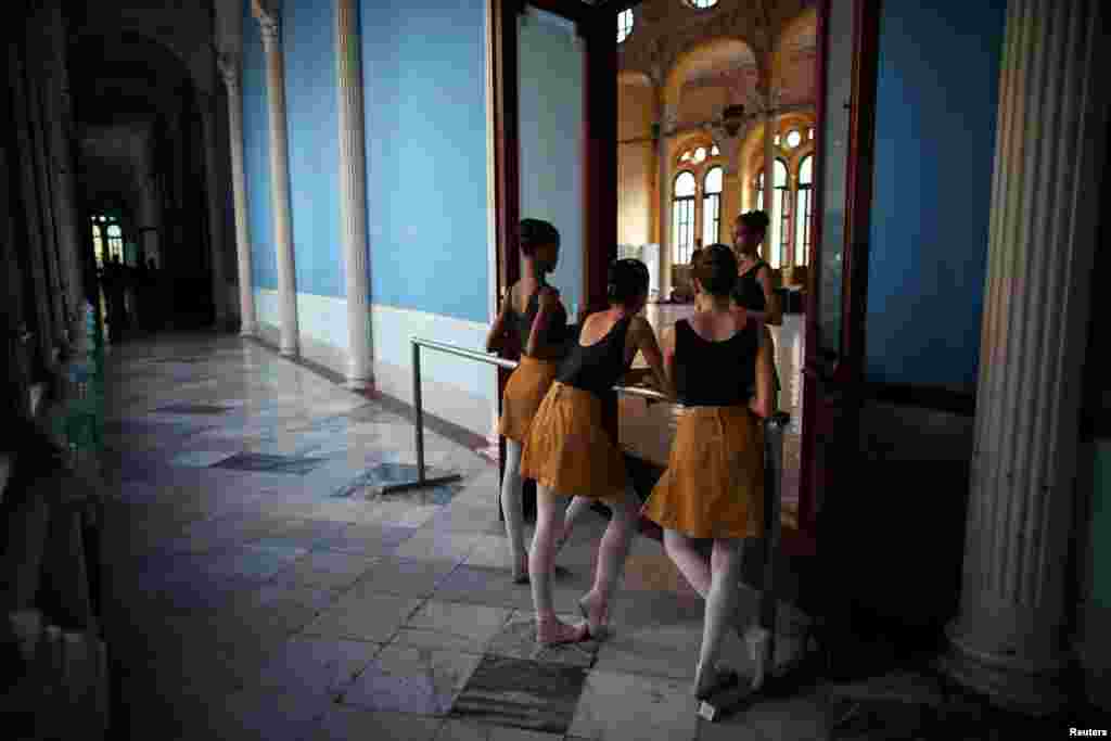 Para siswi sekolah ballet bercengkerama saat istirahat di Havana, Kuba.