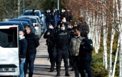 FILE - Security members surround Uighur protesters near the Chinese Embassy in Ankara, Turkey, Feb. 9, 2021.