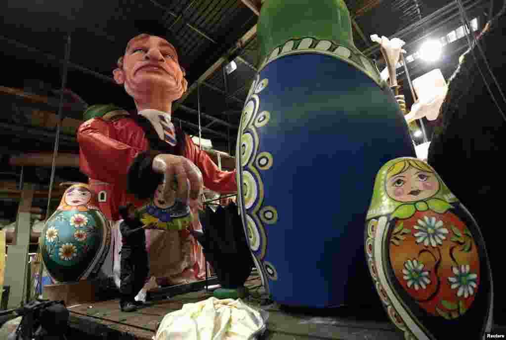 Seorang pekerja memberikan sentuhan akhir pada pelampung berbentuk sosok raksasa Presiden Rusia Vladimir Putin (kiri) selama persiapan parade karnaval di Nice, Prancis. Karnaval Nice yang ke-129 akan berlangsung dari 15 Februari sampai 6 Maret.