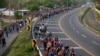 FILE - Central American migrants, part of the caravan hoping to reach the U.S. border, walk in Frontera Hidalgo, Mexico, April 12, 2019.