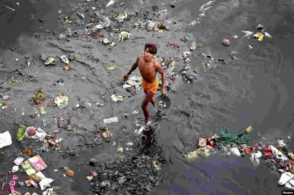 បុរស​ម្នាក់​ដើរកាត់​សំរាម​ក្នុង​ទន្លេ Yamuna ទីក្រុង​ញូវដែលី​ប្រទេស​ឥណ្ឌា។