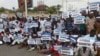 Mourners carry banners which read "Black day" and "Down with al-Shabab" during the anniversary an explosion in the capital of Mogadishu, Somalia, Oct. 14, 2018. 