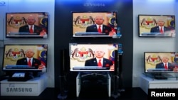 PM Malaysia Najib Razak terlihat di layar televisi sebuah toko elektronik di Kuala Lumpur saat menyampaikan pidato pembubaran parlemen beberap saat yang lalu (Foto: dok).