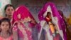 An underaged bride, right, stands with family members during her marriage at a Hindu temple near Rajgarh, Madhya Pradesh state, India, April 17, 2017.