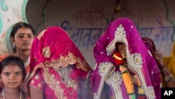 FILE - An underaged bride, right, stands with family members during her marriage at a Hindu temple near Rajgarh, Madhya Pradesh state, India, April 17, 2017.
