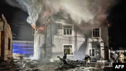 امدادگران در کنار یک ساختمان اداری که در اثر حمله پهپادها آسیب دیده است. کی‌یف.