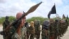 FILE - Al-Shabab fighters display weapons as they conduct military exercises in northern Mogadishu, Somalia, on Oct. 21, 2010. 