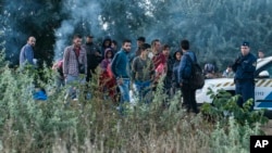 在距离匈牙利首都布达佩斯东南180公里处的匈牙利与塞尔维亚的边界铁道路口，边境执法人员拦截非法移民。（2015年8月25日）