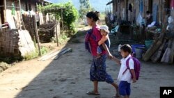 ကချင်ဒေသမှာ မိခင်က ကျောင်းသားလေးကို ကျောင်းပို့နေစဉ် (နိုဝင်ဘာ ၂၀၁၃)