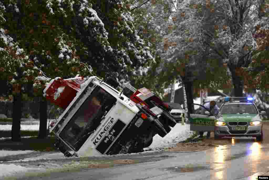 A toppled truck lies in a ditch in front of a police car in Murnau after heavy snow fall in southern Germany. 