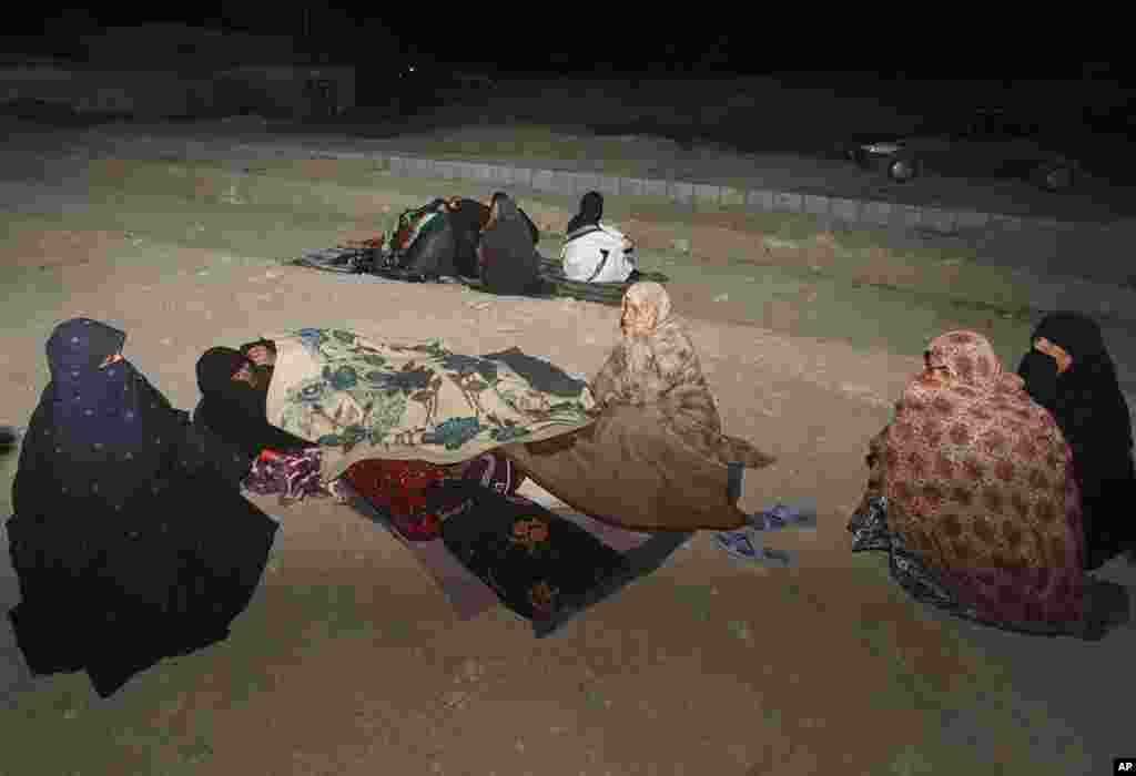 In this photo taken April 16, 2013, Iranians stay outside their homes at the Gosht district after an earthquake hit southeastern Iran. The earthquake toppled homes and shops on both sides of the Iran-Pakistan border killing dozens of people.