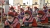 FILE - Workers produce masks for protection against the new coronavirus, at the Songyo Knitwear Factory in Pyongyang, Feb. 6, 2020.