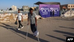 Ljudi prolaze pored ulaza američke terenske bolnice Međunarodnog medicinskog korpusa uoči njene evakuacije u Rafahu u južnom pojasu Gaze 2. juna 2024. godine, usred sukoba između Izraela i Hamasa koji je u toku.