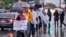 Maestros de Los Angeles protestan bajo la lluvia frente a una secundaria que lleva el nombre de la ciudad durante una huelga de educadores el 14 de enero de 2019. 