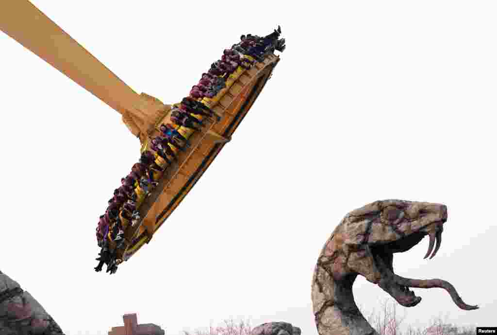 2018年2月18日，中国春节假期，在北京欢乐谷，人们在巨型飞盘上享受惊险和刺激，玩儿的就是心跳。