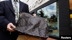资料照：在马里兰州切维蔡斯的一家路易威登商店外，向摄影师展示的一个从中国在线网站购买并发货的假冒 LVMH 手提包。（路透社）