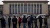 People watch as police officers check visitors in front of the Great Hall of the People during a gathering of the 205-member Central Committee's third annual plenum in Beijing, China, Nov. 9, 2013.