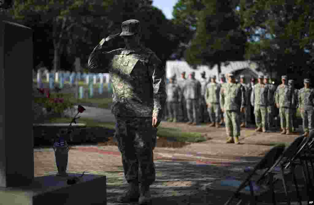 Prajurit John Schena, bersama Batalion Ke-2 Brigade 1 dari Angkatan Pertahanan Negara Bagian Georgia, memberikan hormat setelah meletakkan setangkai mawar di Monumen Peringatan Pearl Harbor di Taman Makam Pahlawan Marietta, Georgia, 26 Mei 2014.