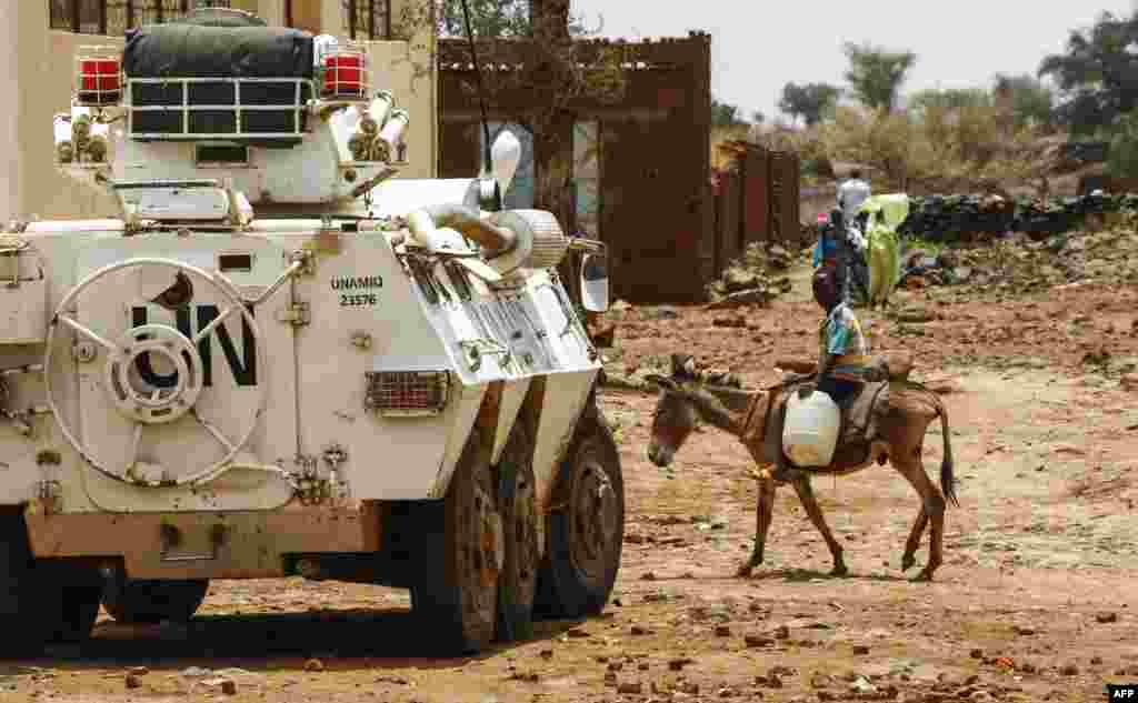 Wani yaro dan Sudan yana wucewa a kan jaki ta gefen dakarun wanzar da zaman lafiya na UNAMID yayin da suke cikin motarsu mai sulke a garin Golo dake tsakiyar Dafur &nbsp;